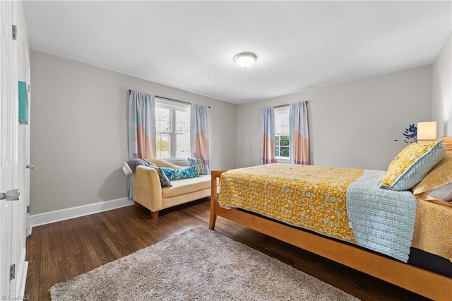 bedroom featuring multiple windows, baseboards, and wood finished floors