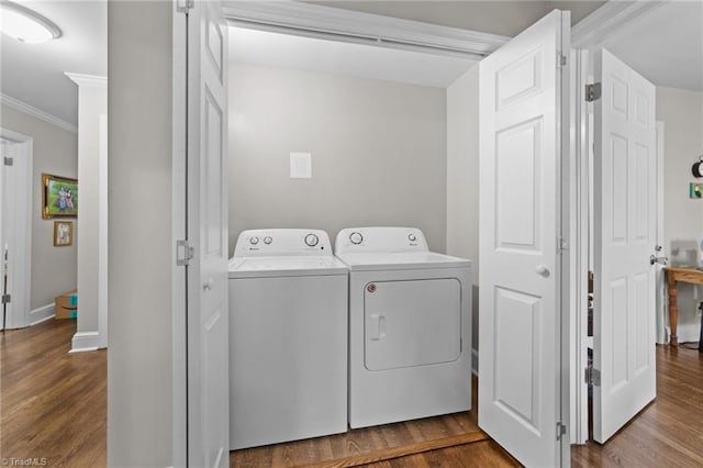 laundry room with dark wood-style floors, laundry area, crown molding, and washer and dryer