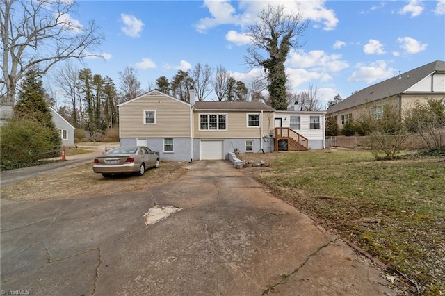 view of front of house with a garage, a front yard, concrete driveway, and a chimney