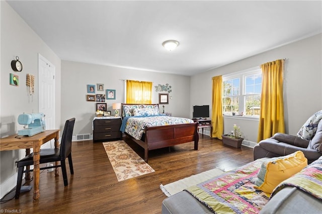 bedroom with dark wood-style flooring, visible vents, and baseboards