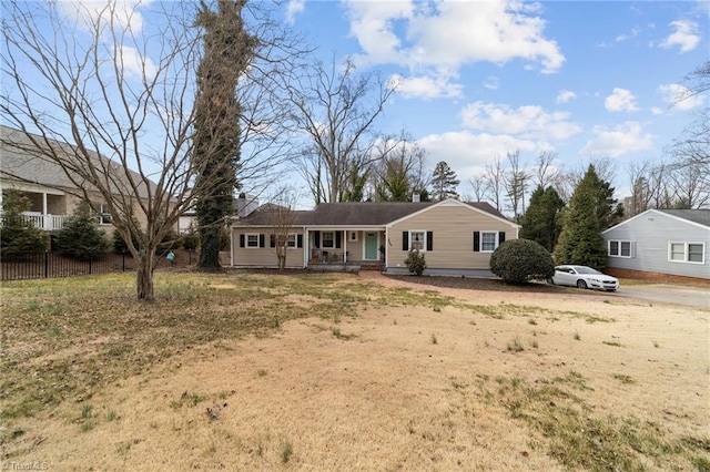 ranch-style home featuring covered porch and fence