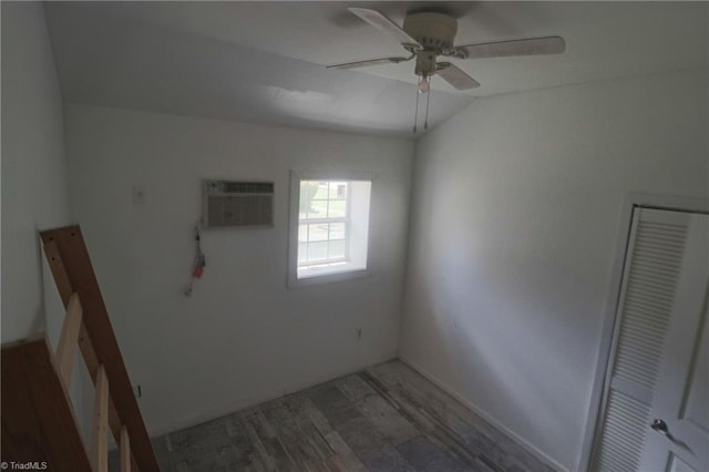 interior space with a wall mounted AC, ceiling fan, a closet, and wood-type flooring