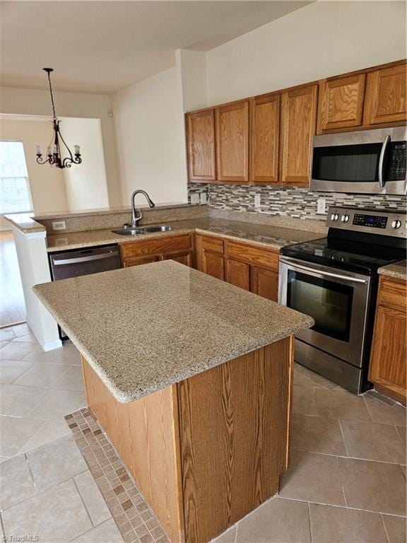 kitchen featuring a sink, stainless steel appliances, decorative backsplash, and brown cabinetry