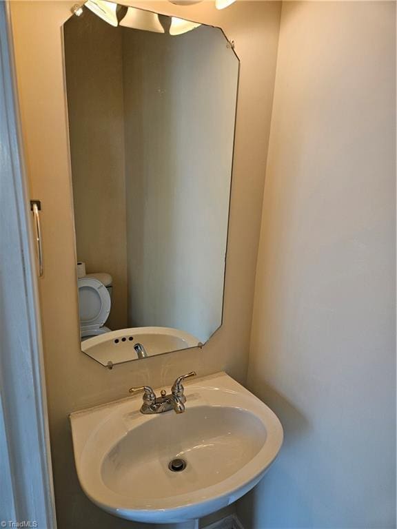 half bathroom featuring toilet and a sink