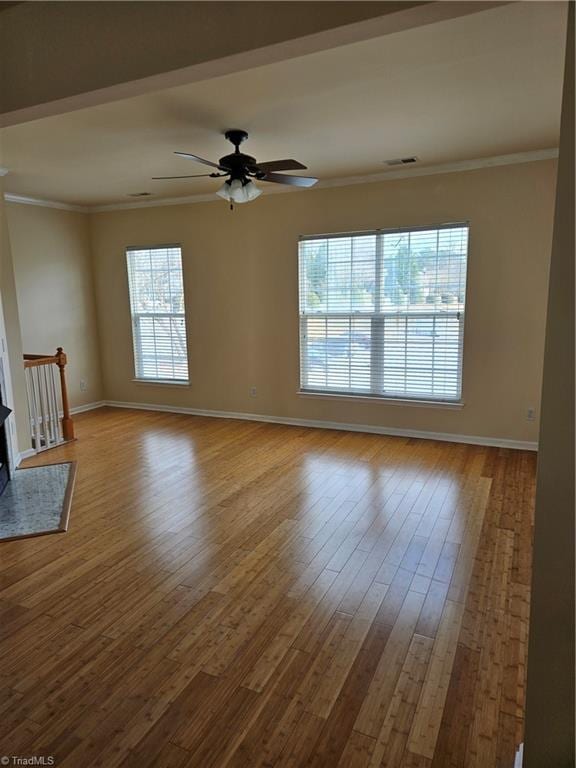 unfurnished room featuring visible vents, crown molding, ceiling fan, baseboards, and wood finished floors