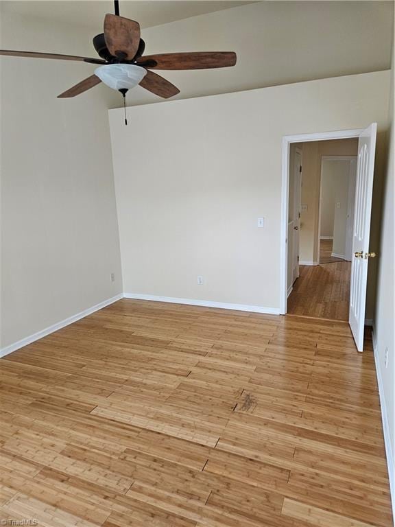 unfurnished room with baseboards, light wood-style floors, and a ceiling fan