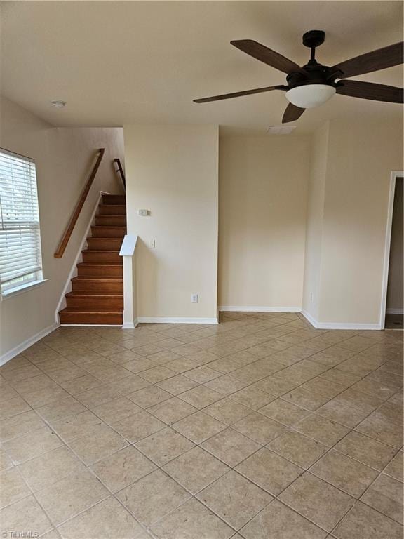 empty room with light tile patterned floors, stairs, and baseboards