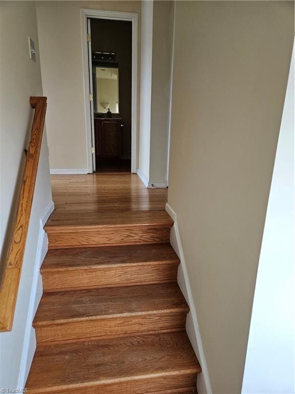 staircase with wood finished floors and baseboards