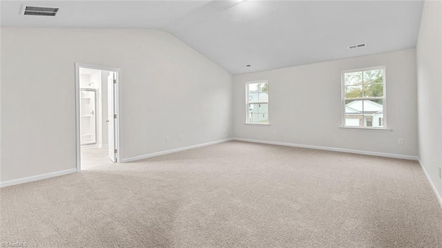 carpeted empty room with lofted ceiling