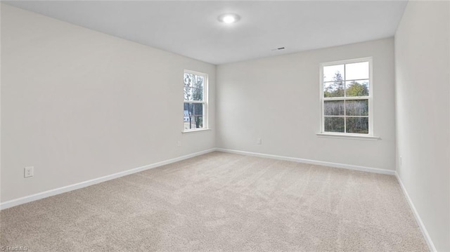 unfurnished room featuring light colored carpet