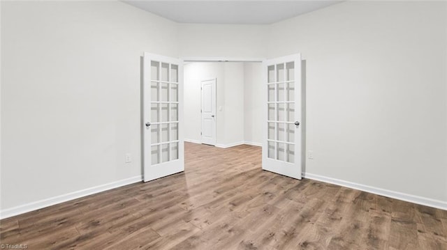 empty room featuring french doors and hardwood / wood-style floors