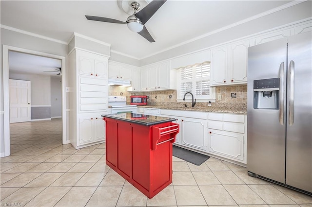 kitchen with under cabinet range hood, light tile patterned flooring, appliances with stainless steel finishes, and ceiling fan