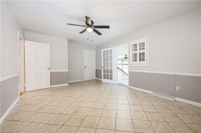 unfurnished room featuring light tile patterned floors, a wainscoted wall, and ceiling fan