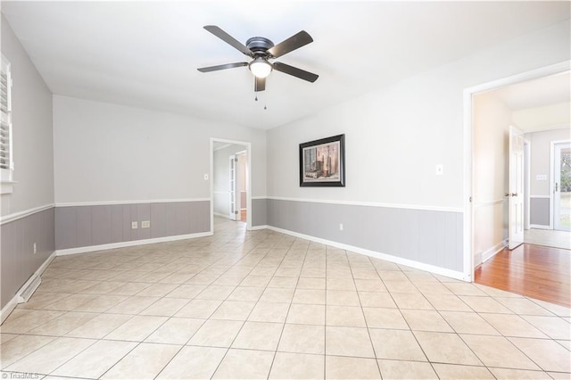 spare room with wainscoting and a ceiling fan