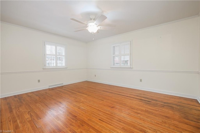 empty room with crown molding, baseboards, visible vents, and light wood finished floors