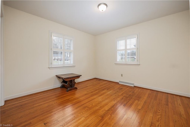 spare room featuring visible vents, light wood-type flooring, and baseboards