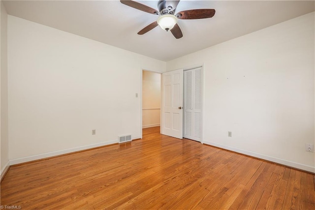 unfurnished room featuring a ceiling fan, light wood-type flooring, and baseboards