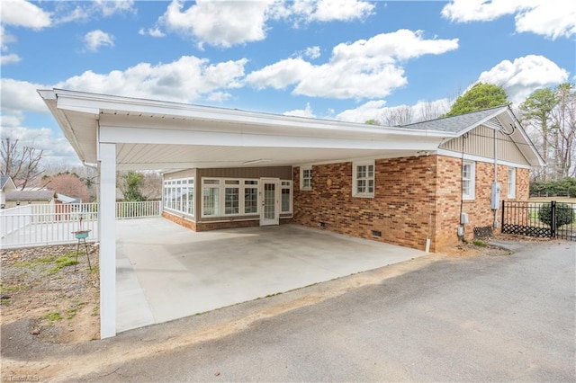 exterior space with a carport, fence, and brick siding