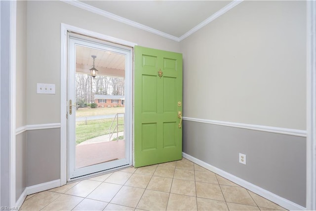 foyer entrance with crown molding, light tile patterned floors, and baseboards