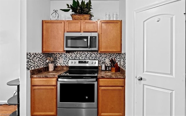 kitchen featuring dark stone countertops, decorative backsplash, and appliances with stainless steel finishes