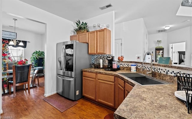 kitchen with stainless steel fridge, dark hardwood / wood-style flooring, tasteful backsplash, sink, and pendant lighting