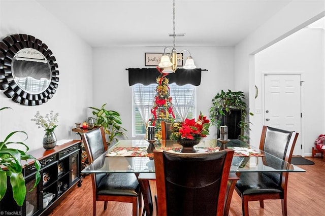 dining room featuring hardwood / wood-style floors and an inviting chandelier