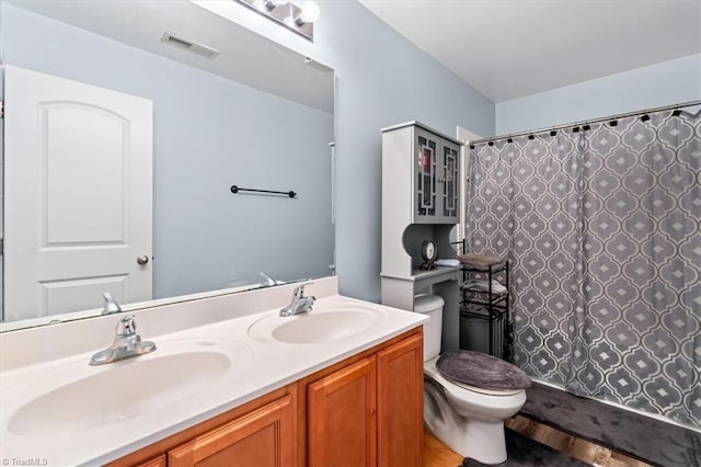 bathroom with hardwood / wood-style floors, vanity, toilet, and curtained shower