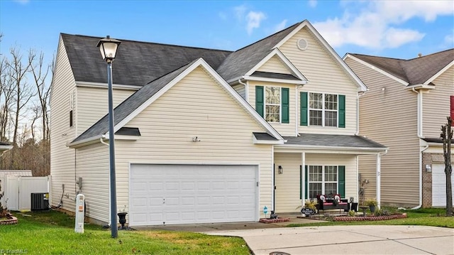 view of front of house with central AC unit, a garage, and a front yard