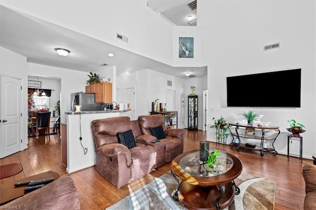 living room featuring a high ceiling and light wood-type flooring