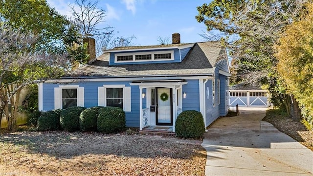 bungalow featuring a chimney and a garage