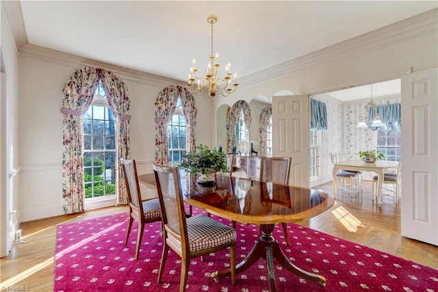 dining area featuring a notable chandelier, wood finished floors, and ornamental molding