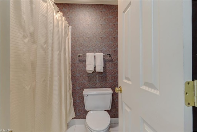 bathroom featuring baseboards, toilet, and wallpapered walls