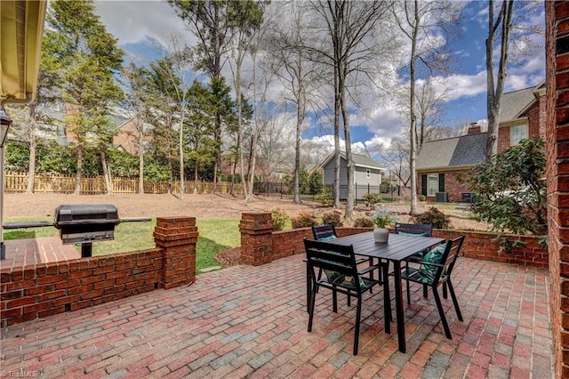 view of patio / terrace with outdoor dining space, a fenced backyard, and a grill