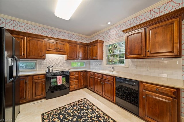 kitchen featuring crown molding, tasteful backsplash, a sink, black appliances, and wallpapered walls