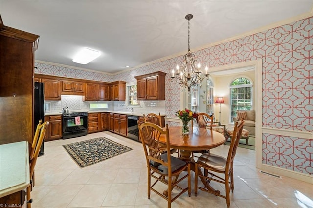 dining room with light tile patterned floors, ornamental molding, wallpapered walls, and a chandelier