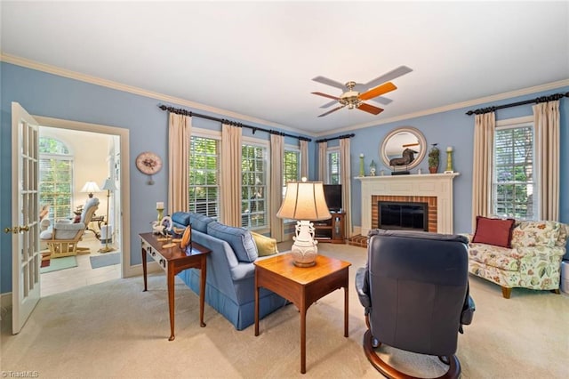 living area featuring ornamental molding, a brick fireplace, light carpet, baseboards, and ceiling fan