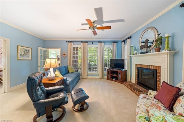 living room featuring carpet flooring, crown molding, ceiling fan, a fireplace, and baseboards