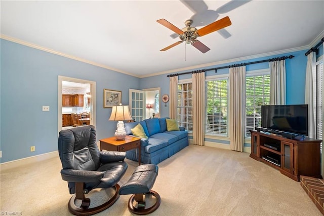living room featuring crown molding, ceiling fan, light colored carpet, and baseboards