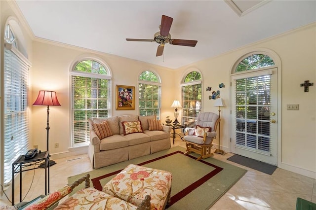 tiled living room featuring crown molding, ceiling fan, and baseboards