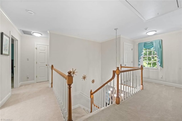 hall with attic access, visible vents, an upstairs landing, ornamental molding, and light carpet