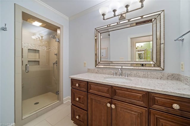 bathroom featuring vanity, ornamental molding, tile patterned flooring, and a stall shower