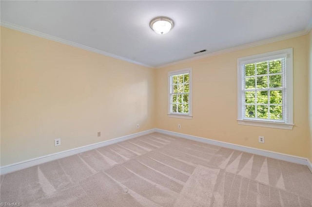 spare room featuring visible vents, baseboards, crown molding, and light colored carpet