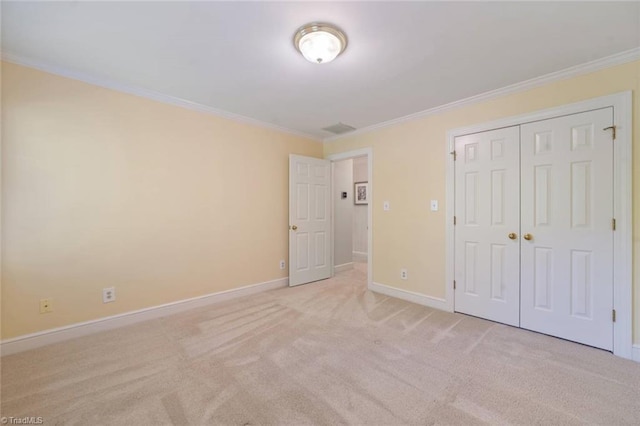 unfurnished bedroom featuring baseboards, ornamental molding, a closet, and light colored carpet
