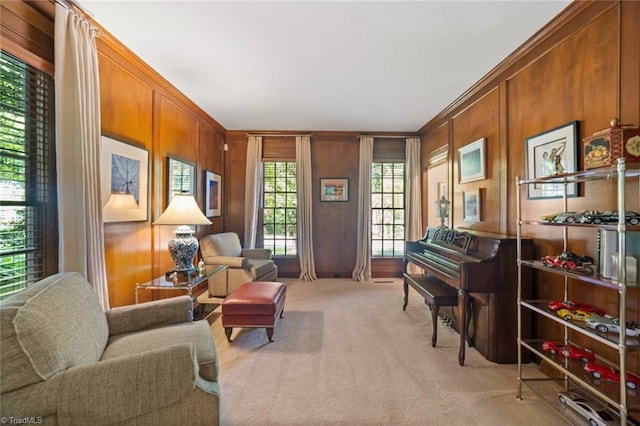 living area featuring crown molding, wooden walls, and light carpet