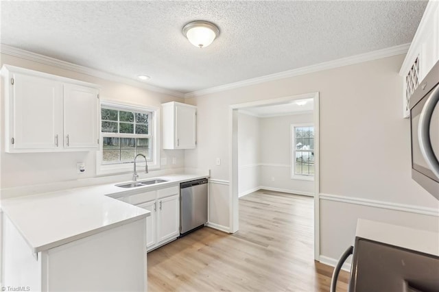 kitchen featuring sink, crown molding, white cabinets, stainless steel dishwasher, and light wood-type flooring