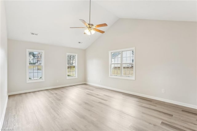 unfurnished room with vaulted ceiling, a healthy amount of sunlight, and light hardwood / wood-style flooring