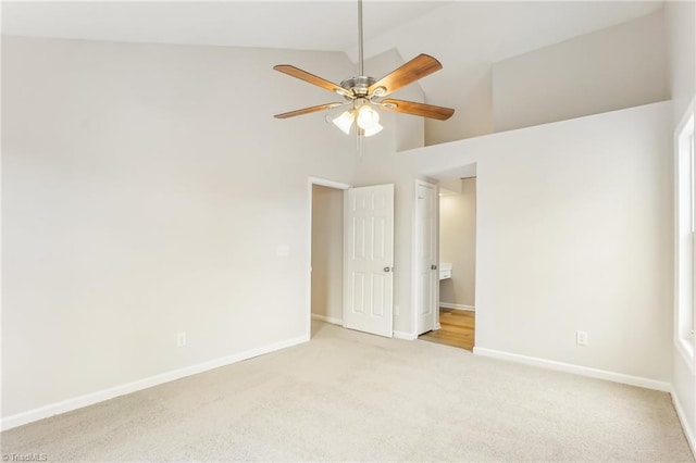 carpeted empty room featuring high vaulted ceiling and ceiling fan