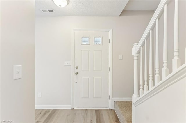 entryway featuring a textured ceiling and light wood-type flooring