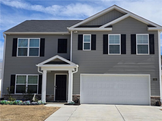 view of front facade with a garage, stone siding, and concrete driveway