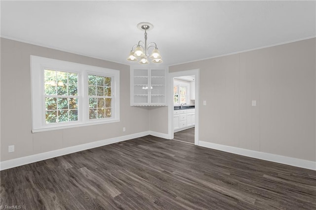 unfurnished dining area with dark hardwood / wood-style flooring, sink, crown molding, and an inviting chandelier